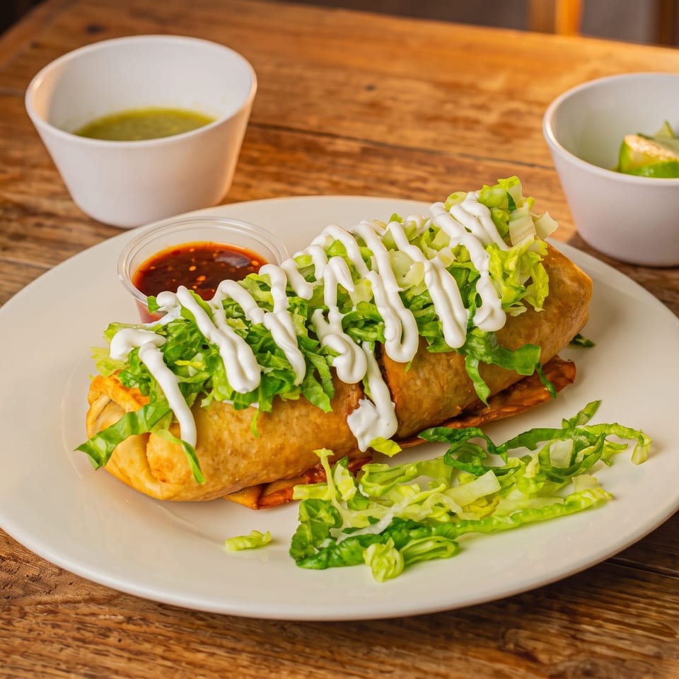 Crispy golden fried burrito topped with shredded lettuce and sour cream, served with salsa and lime.