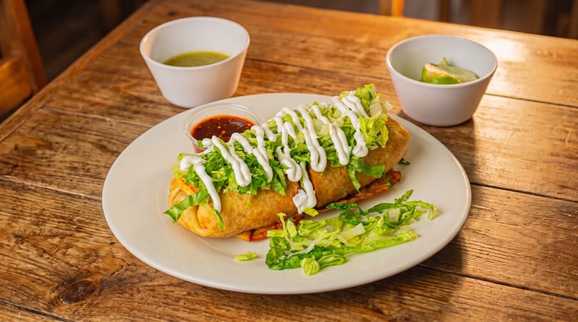 Crispy golden fried burrito topped with shredded lettuce and sour cream, served with salsa and lime.